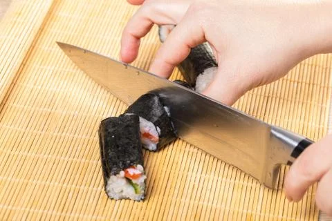 Chef cuts rolls, hands close-up Foto stock