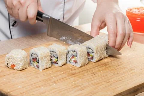 Chef cuts rolls, hands close-up Stock Photos