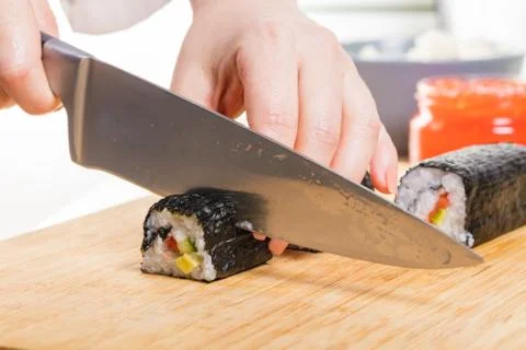 Chef cuts rolls, hands close-up Foto stock