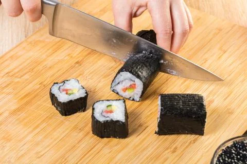 Chef cuts rolls, hands close-up Stock-Fotos