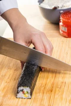 Chef cuts rolls, hands close-up Stock Photos