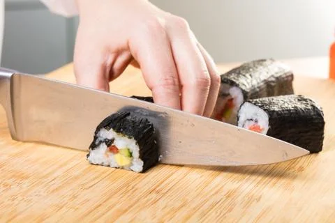 Chef cuts rolls, hands close-up Stock Photos