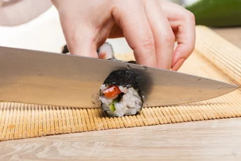 Chef cuts rolls, hands close-up Stock Photos