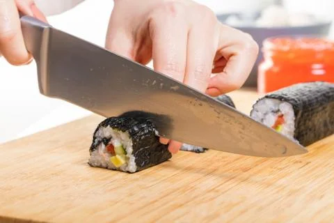 Chef cuts rolls, hands close-up Stock Photos