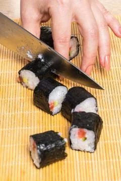 Chef cuts rolls, hands close-up Stock Photos