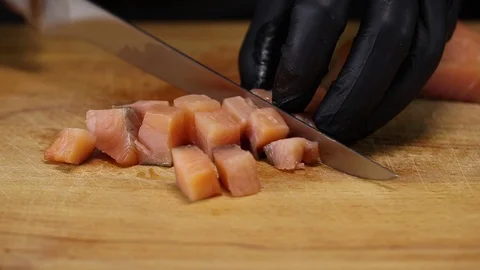 Chef cuts the salmon filet into cubes Stock Footage 122995245