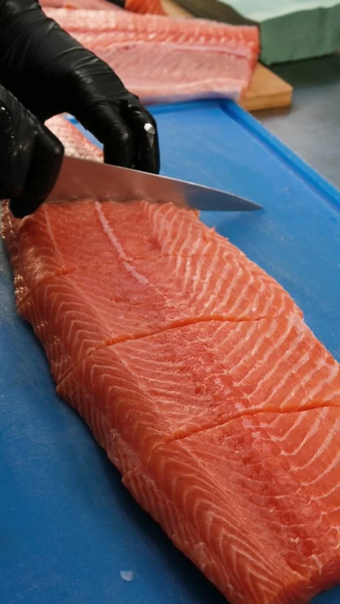 The chef cuts salmon fillet on a cutting board. Stock Footage 262582062