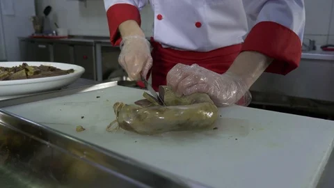 Chef cuts the sausage and puts the pieces on a plate. Stock Footage 88898685
