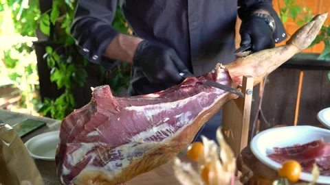 The chef cuts slices of jamon with a knife Stock Footage 247713446