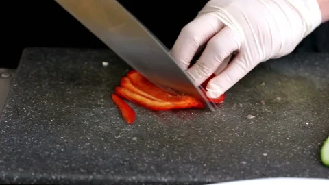 Chef cuts slices of red peppers with knife on cutting board 스톡 동영상 98798059