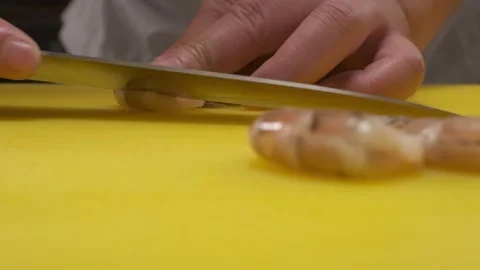 The chef cuts srimps on a board with a knife Stock Footage 221415937