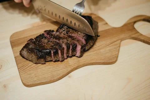 The chef cuts the steak with a large knife Stock Photos