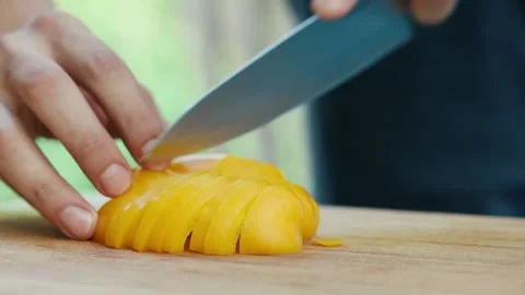 Chef cuts sweet yellow pepper close up of hand and knife full HD video Stock Footage 130789072