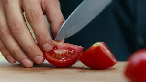 Chef cuts a tomato close up hands and knife full HD video Stock Footage 130770528