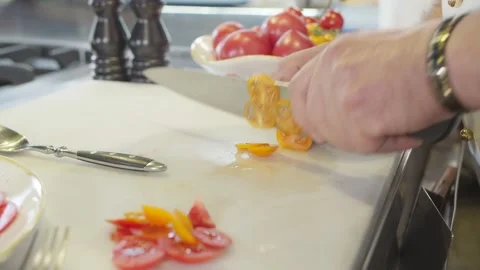 Chef cuts tomato on cutting board in slow motion Stock Footage 230970925