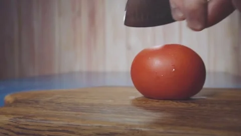 Chef cuts the tomato in half Stock Footage 73816307