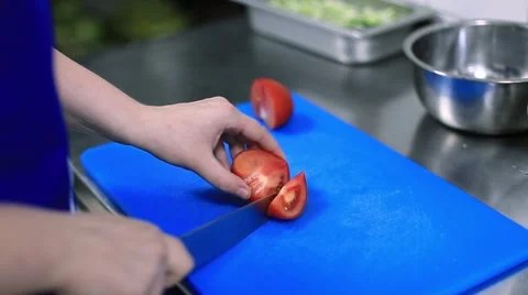 Chef cuts the tomato in the kitchen of the restaurant Stock Footage 65179106