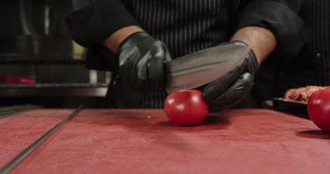 Chef cuts tomatoes. Chef prepares vegetables in a restaurant. Selected focus Stock Footage 266725625