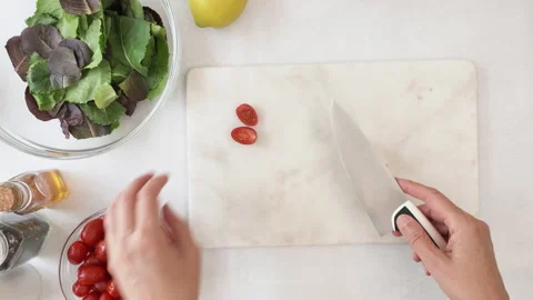 Chef cuts tomatoes on marble cutting board.  Stock Footage 144486316