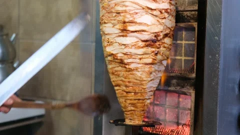 Chef cuts the turkish doner cooked on the fire Stock Footage 146290072