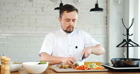 Chef cuts vegetables on board, cooking in restaurant kitchen. Vegetarian food Stock Footage 133392506