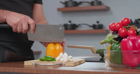 The chef cuts yellow pepper with an axe in slow motion. The process of cooking Stock Footage 258382395