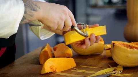 Chef is cutting and peeling a pumpkin. Stock Footage 88943136