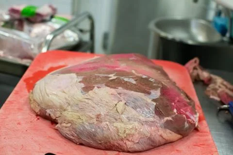 Chef cutting and preparing a large piece of meat Stock Photos