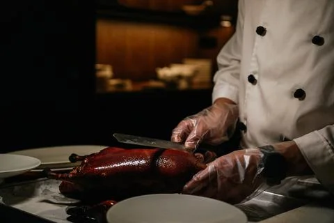 Chef cutting and serving roasted Beijing duck in luxury restaurant 스톡 사진