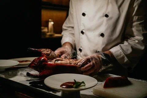 Chef cutting and serving roasted Beijing duck in luxury restaurant Foto stock