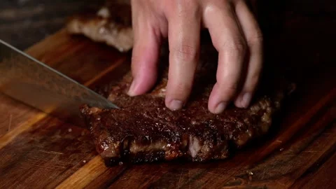 Chef cutting beef steak with knife Stock Footage 263770331