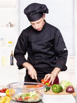 Chef cutting bell peppers in kitchen Stock Photos