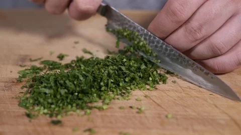The chef on a cutting board cut the fresh parsley Stock Footage 128543571