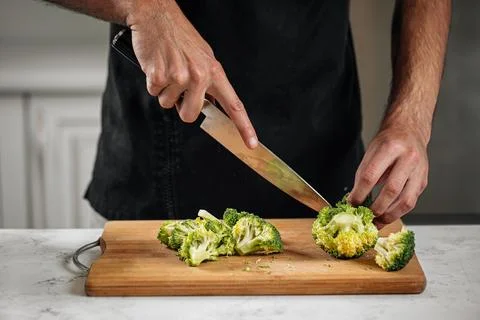 Chef cutting broccoli preparing meal Stock Photos