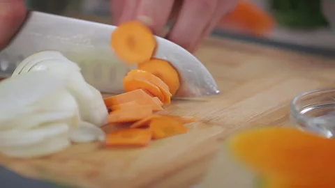 Chef Cutting Carrot With Large Sharp Kitchen Knife On Wooden Chopping Board. Stock Footage 313733085