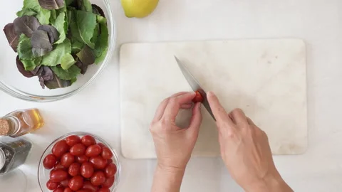 Chef cutting cherry tomatoes. Lettuce salad with cherry tomatoes recipe Stock Footage 138540739