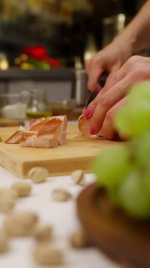 Chef cutting chicken breast into cubes on wooden board Stock Footage 310928589