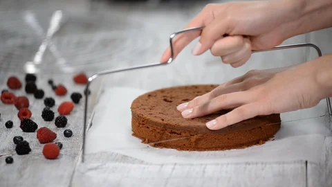 Chef cutting chocolate cake layers and stacking them. Stock Footage 98556388