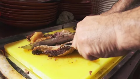 Chef cutting cooked pieces of meat for pilaf with a knife on a cutting board Stock Footage 263099389