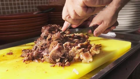 Chef cutting cooked pieces of meat for pilaf with a knife on a cutting board Stock Footage 270727206