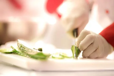 Chef Cutting cucumber on board Stock Photos