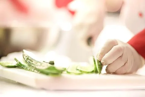 Chef Cutting cucumber on board Stock Photos