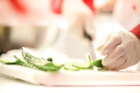 Chef Cutting cucumber on board Stock Photos