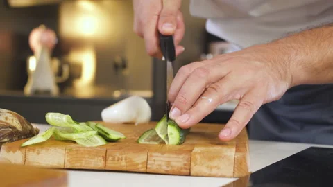 Chef Cutting Cucumber With a Knife On Cutting Board In Restaurant Kitchen. Stock-Footage 151922164