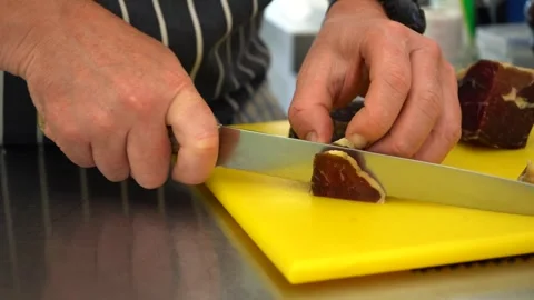 Chef Cutting Cured Meat with Sharp Knife Stock Footage 283666827