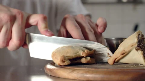 Chef cutting empanadas into half in kitchen Video stock 238638360