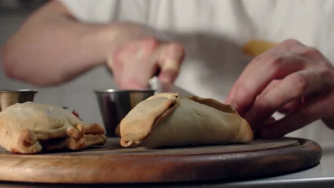Chef cutting empanadas into half in kitchen Video stock 238638665