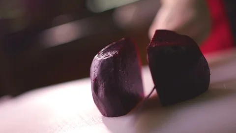 Chef cutting fresh beetroot vegetable on a white background Stock Footage 119300354