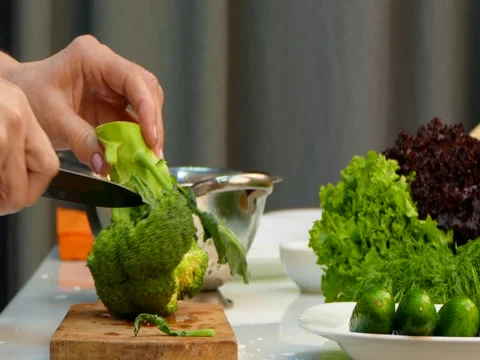 Chef Cutting Fresh Broccoli On Carving Board Stock Footage 83461271