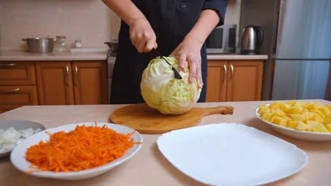 Chef cutting fresh cabbage with knife on a wooden board Stock Footage 328594203